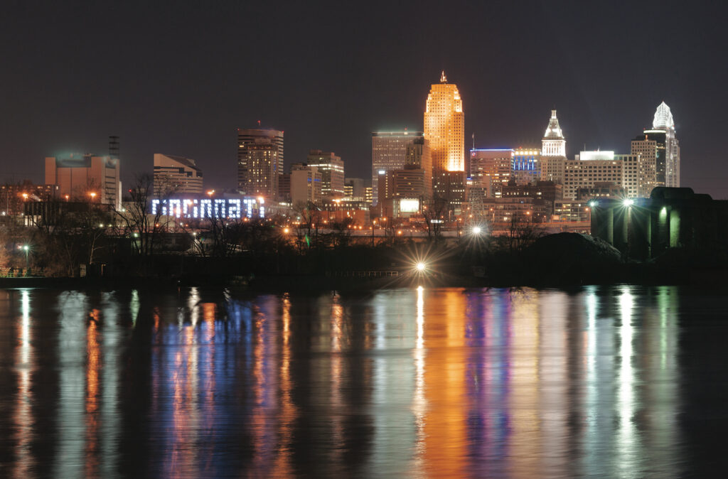 Office buildings light are reflected in the flowing river called Ohio